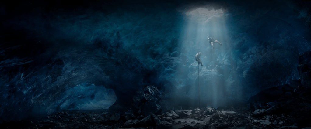 Two persons rappelling into an icy cave