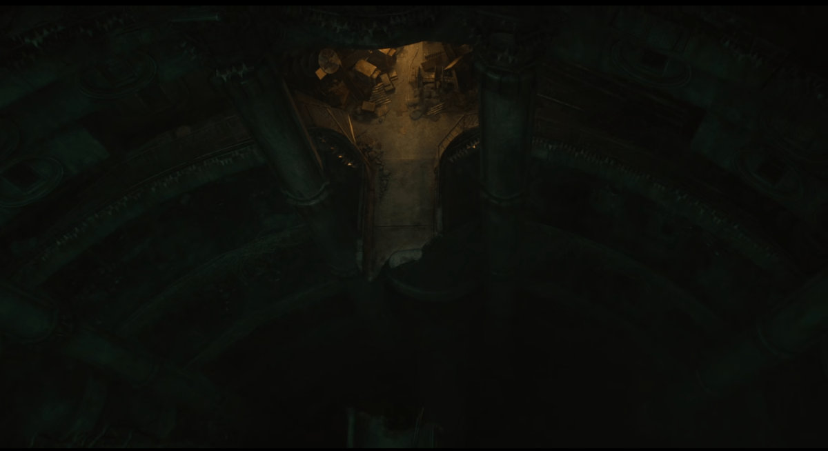 A top-down view of a broken bridge in a deep stairwell